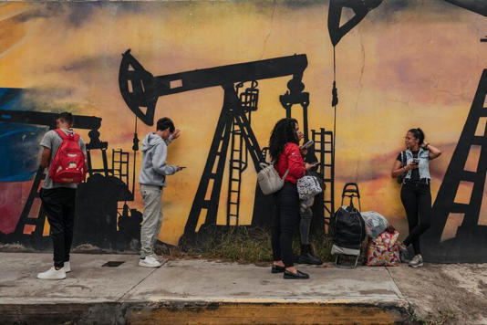 Pessoas do lado de fora da sede da PDVSA, a estatal venezuelana de petróleo: queda na produção sob Maduro Foto: Adriana Loureiro Fernandez/The New York Times