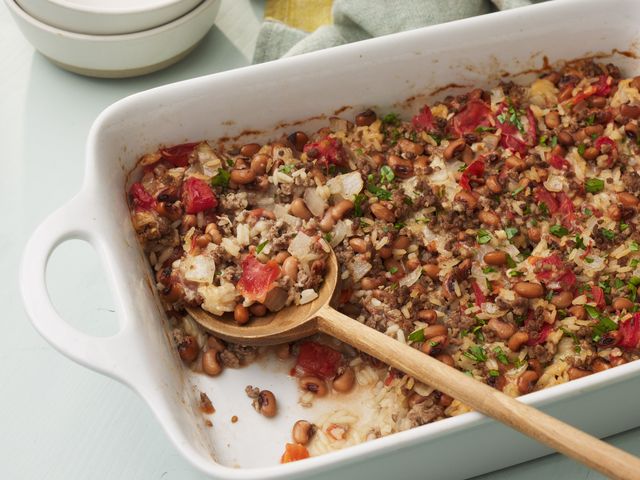 A black eyed pea casserole with a wood spoon removing a serving