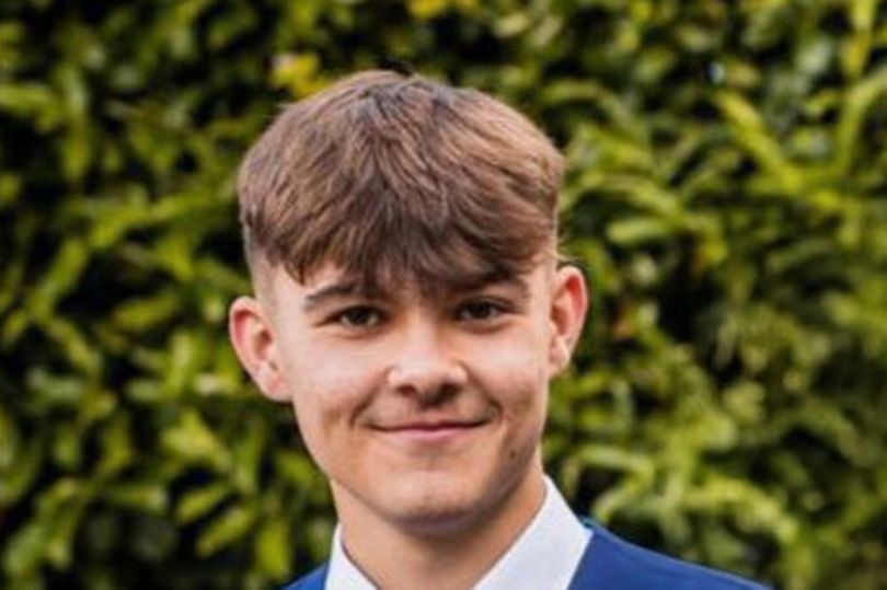Charlie Cosser smiles wearing a blue shirt and waistcoat with a red tie