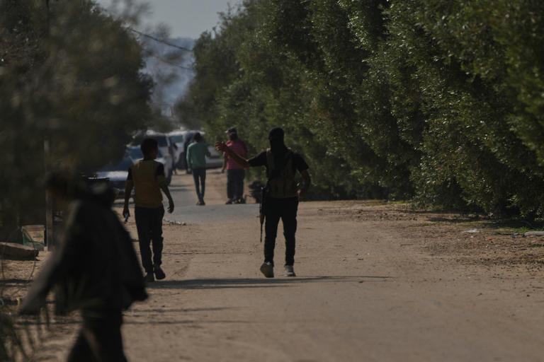 Hombres armados de Hamás con el rostro cubierto toman posiciones en Jan Yunis, en el sur de Gaza, antes de la entrega de los rehenes a la Cruz Roja, este lunes.