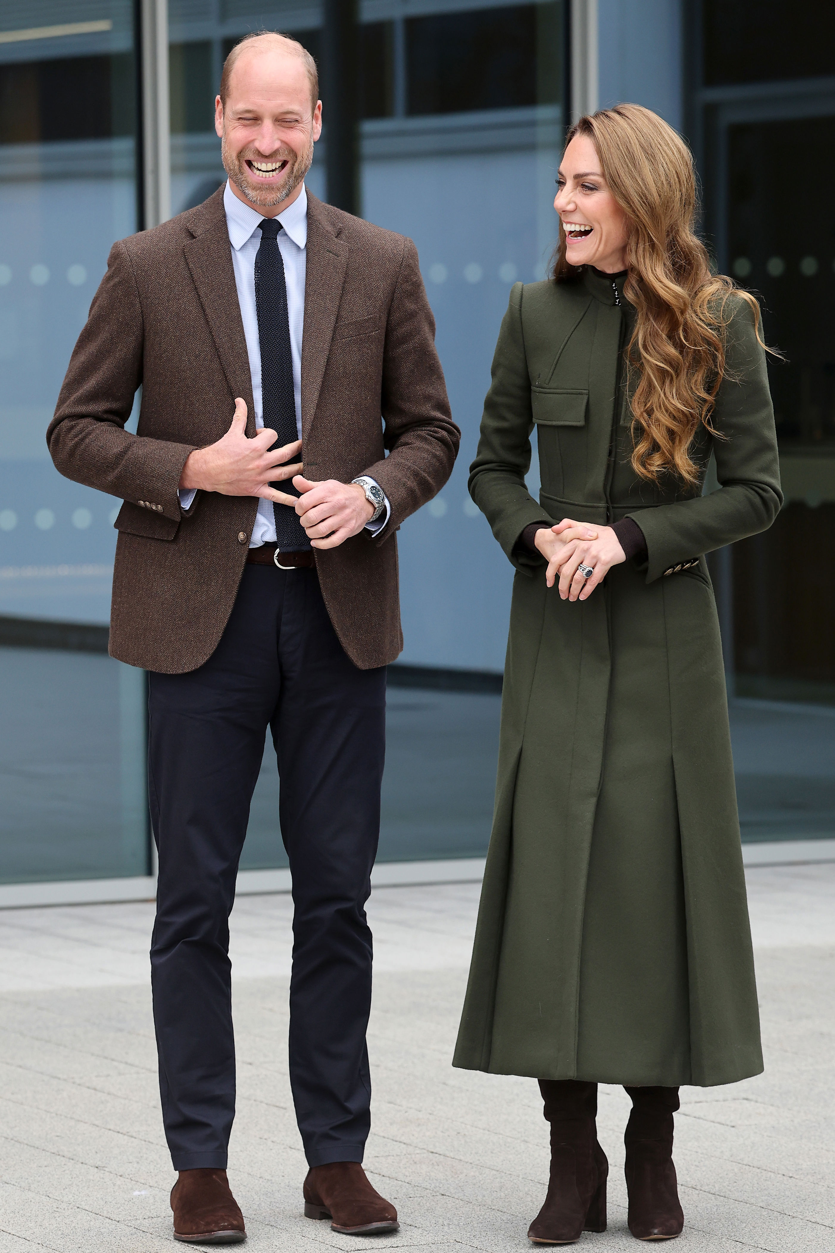 Kate Middleton wearing a green coat and Prince William in a brown blazer n Northern Ireland