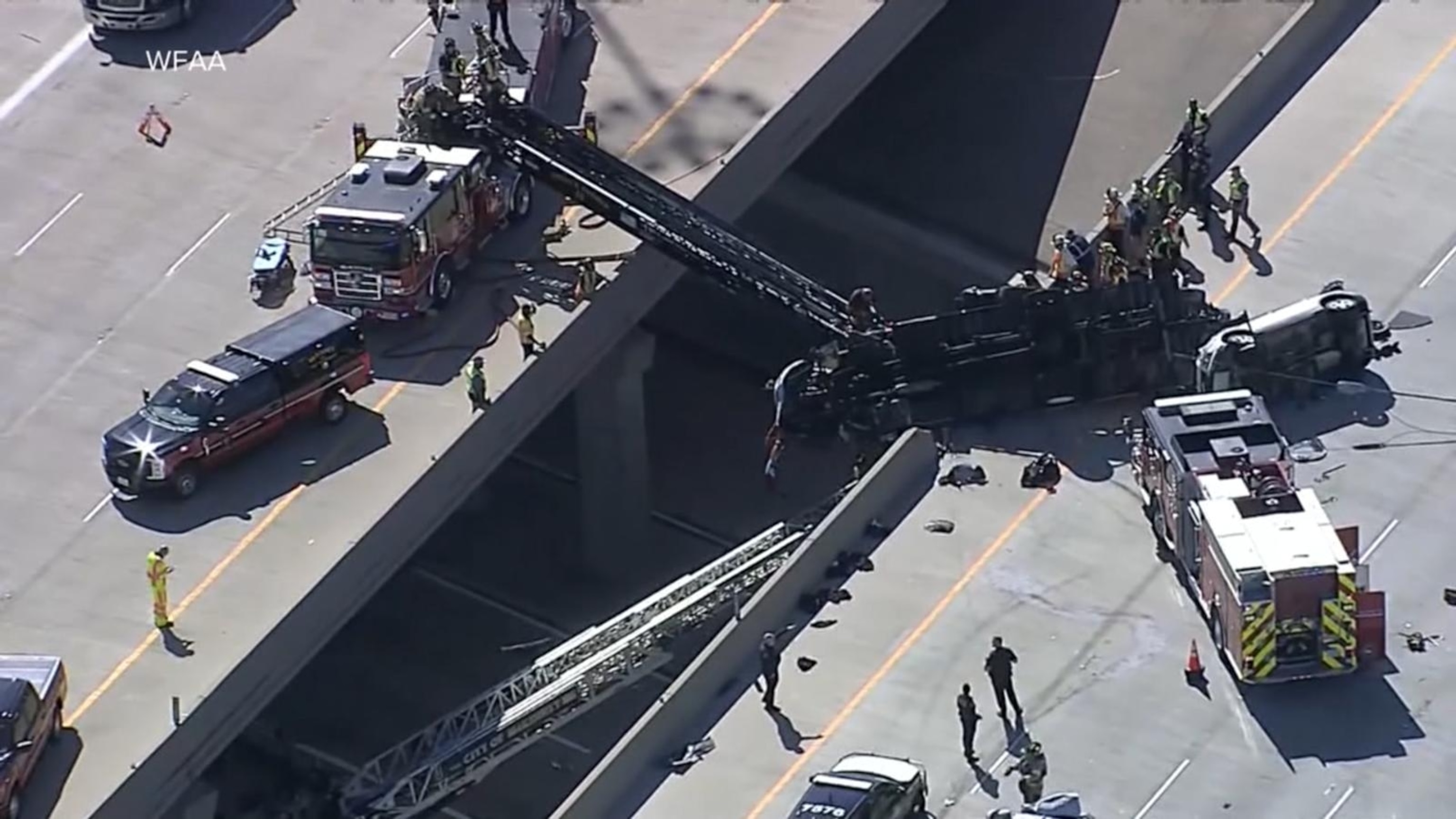 Truck driver rescued from cab of truck dangling over edge of overpass