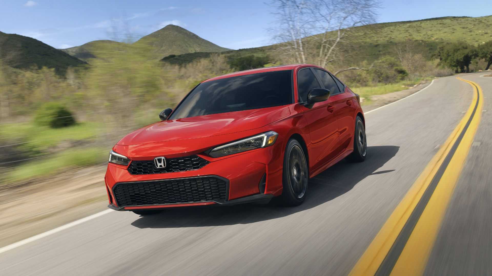 Dynamic front 3/4 shot of a red 2025 Honda Civic Sedan Sport Touring Hybrid.