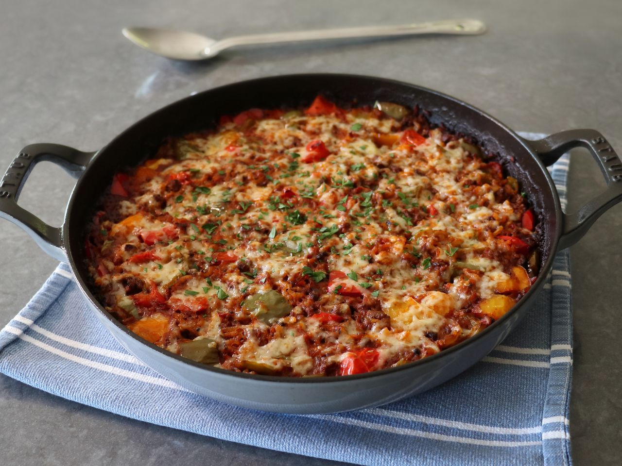 2-handle braising pan with stuffed bell pepper casserole on blue towel