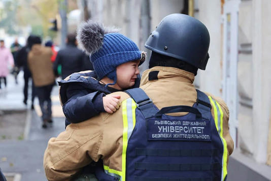 A firefighter evacuates a child following a Russian drone attack that struck a kindergarten in Kharkiv, eastern Ukraine on Wednesday. (Ukrainian Emergency Service / AFP - Getty Images)