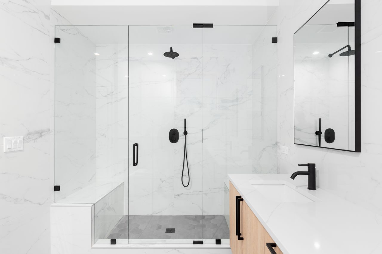 White marble walk-in shower with black hardware