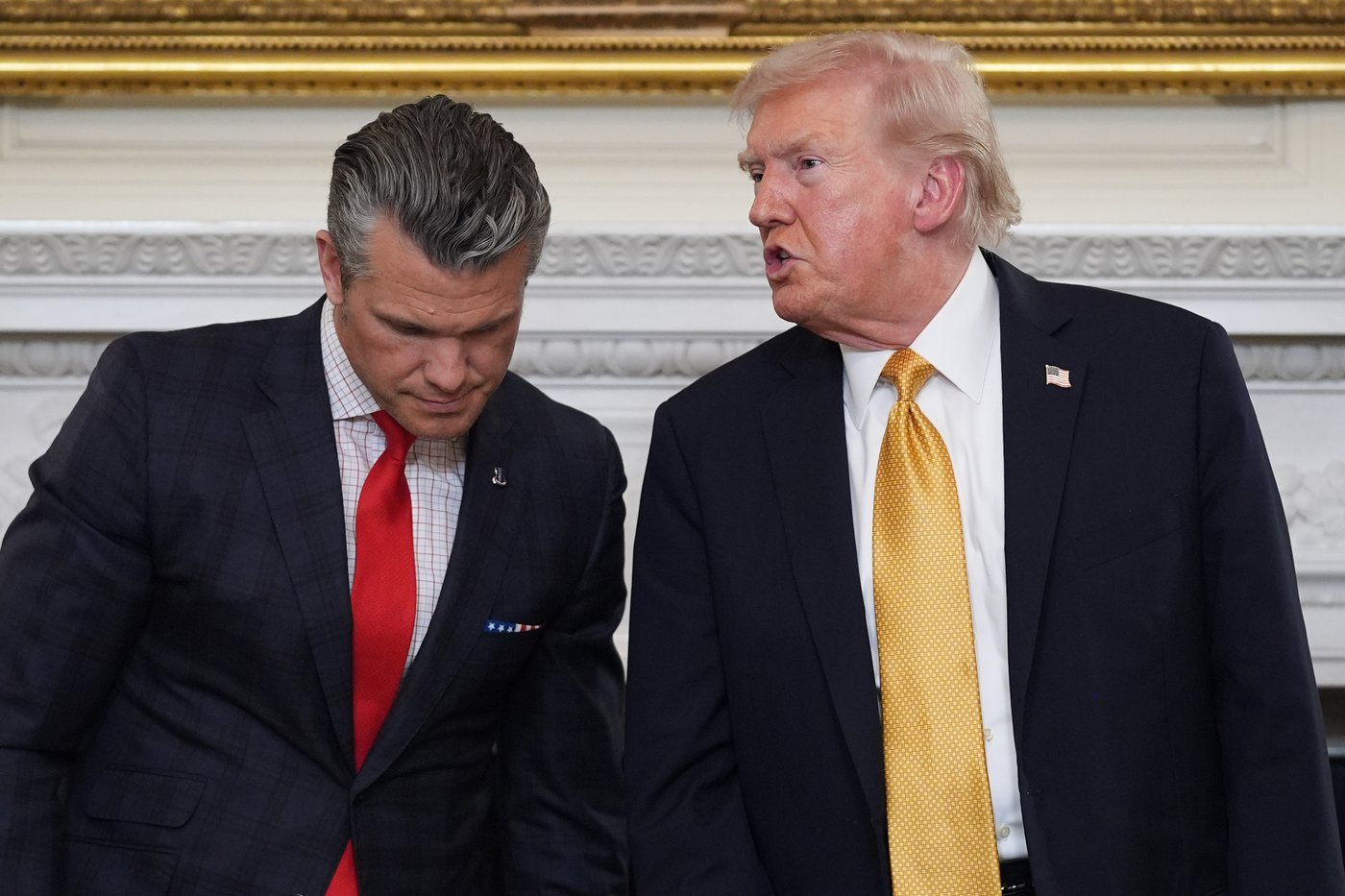 President Donald Trump talks with Defense Secretary Pete Hegseth after a roundtable on criminal cartels in the State Dining Room of the White House, Thursday, Oct. 23, 2025, in Washington. (AP Photo/Evan Vucci)
