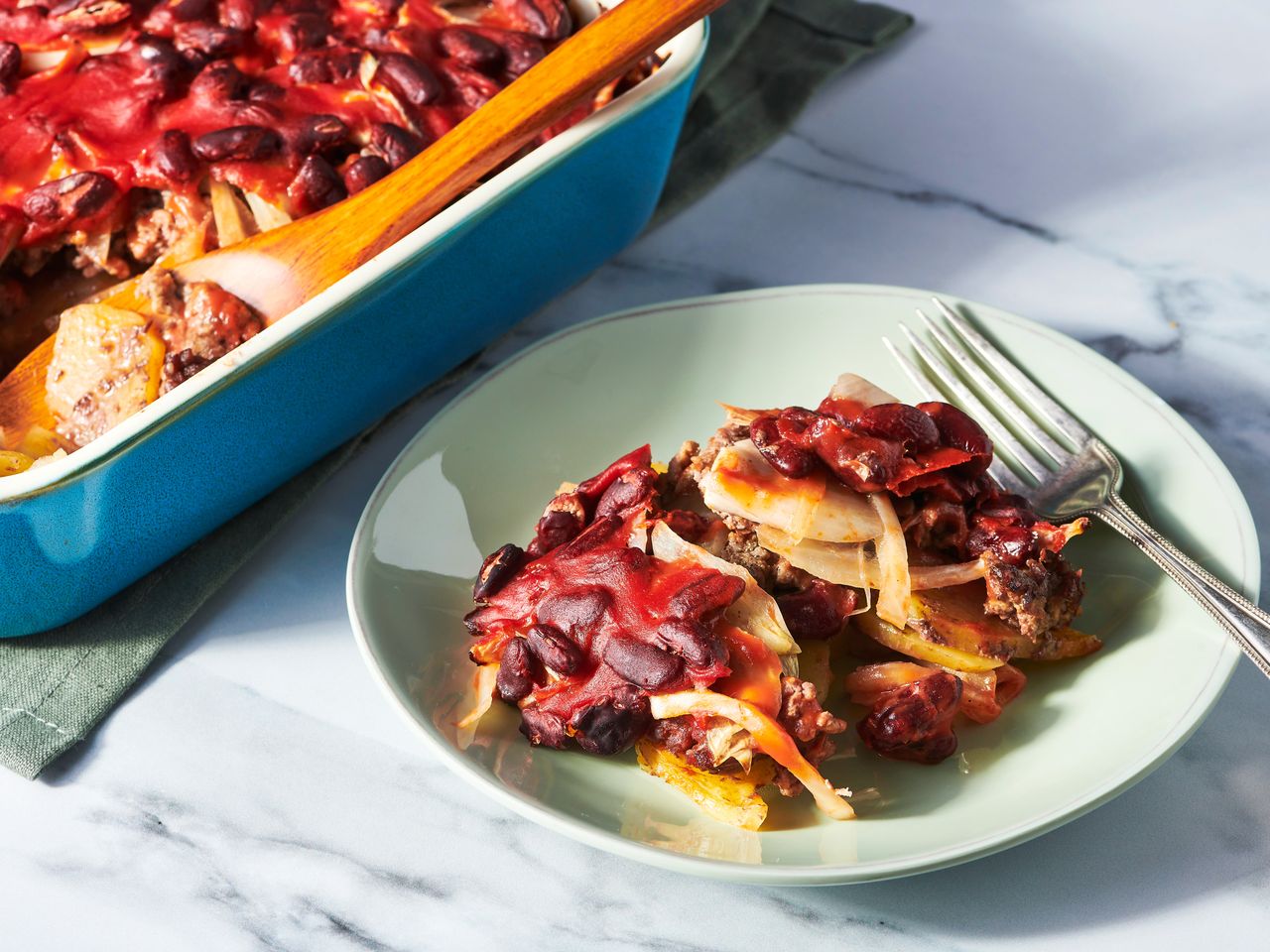A plated serving of Grandma Flo's shipwreck next to a baking dish