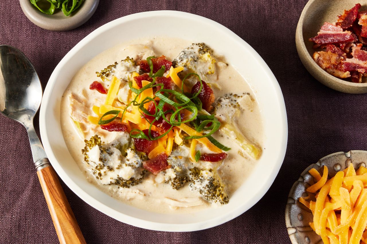 Overhead photo of slow cooker Loaded Broccoli Soup with toppings.