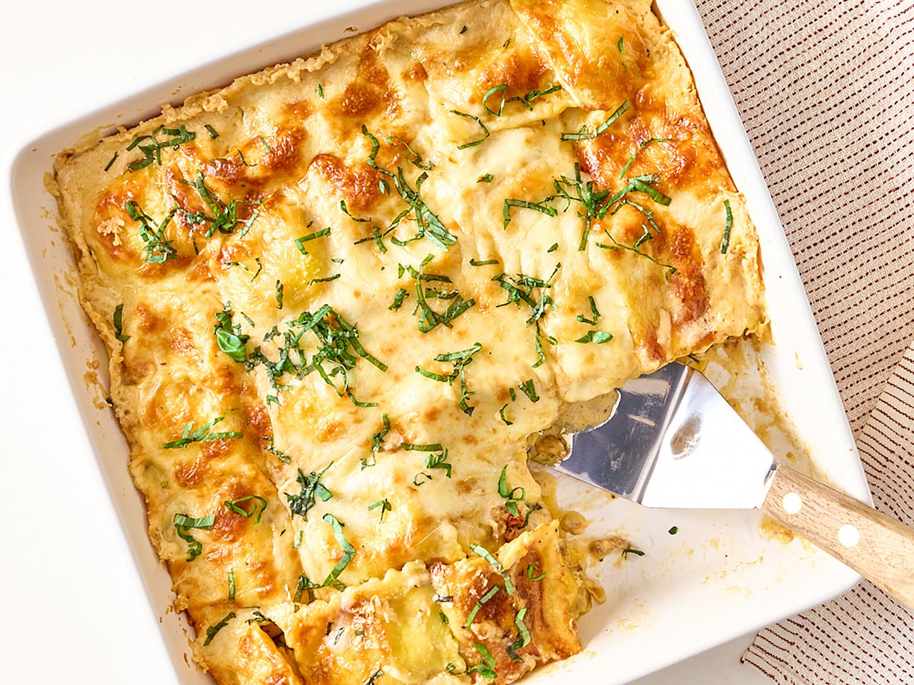 Creamy ravioli bake topped with Alfredo sauce and cheese
