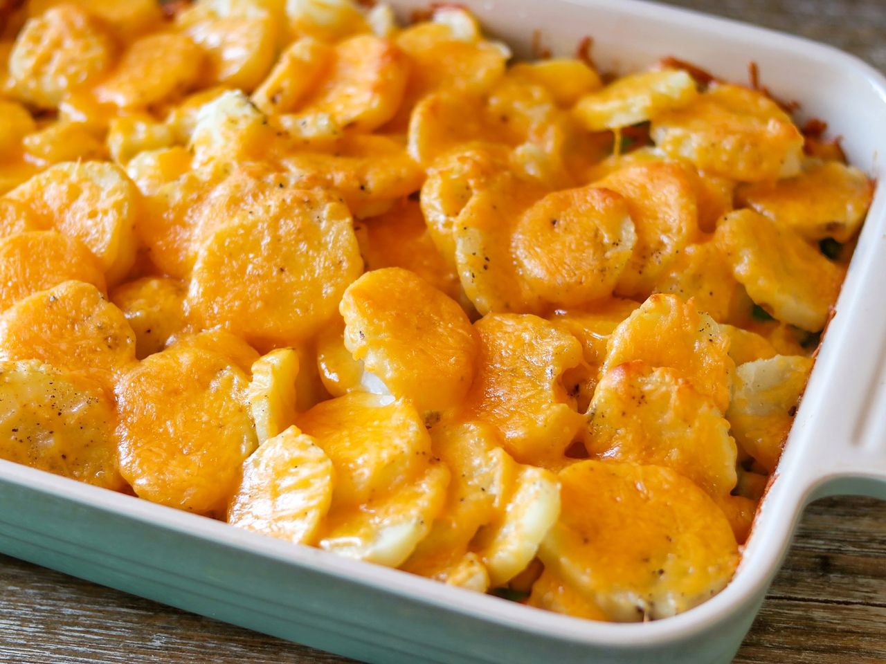 rectangular casserole with sliced potato and cheese on top