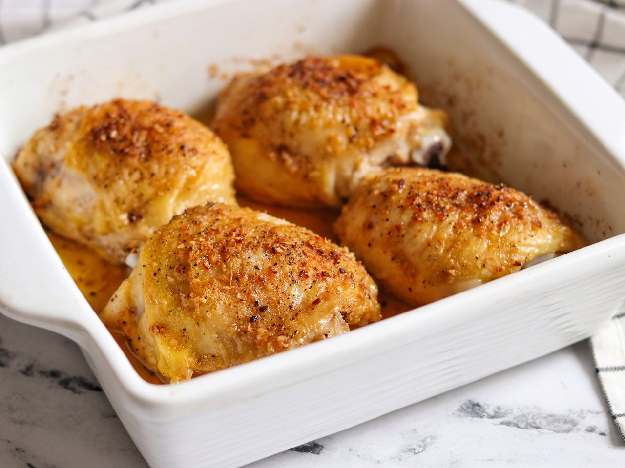 Baked chicken thighs in white casserole dish