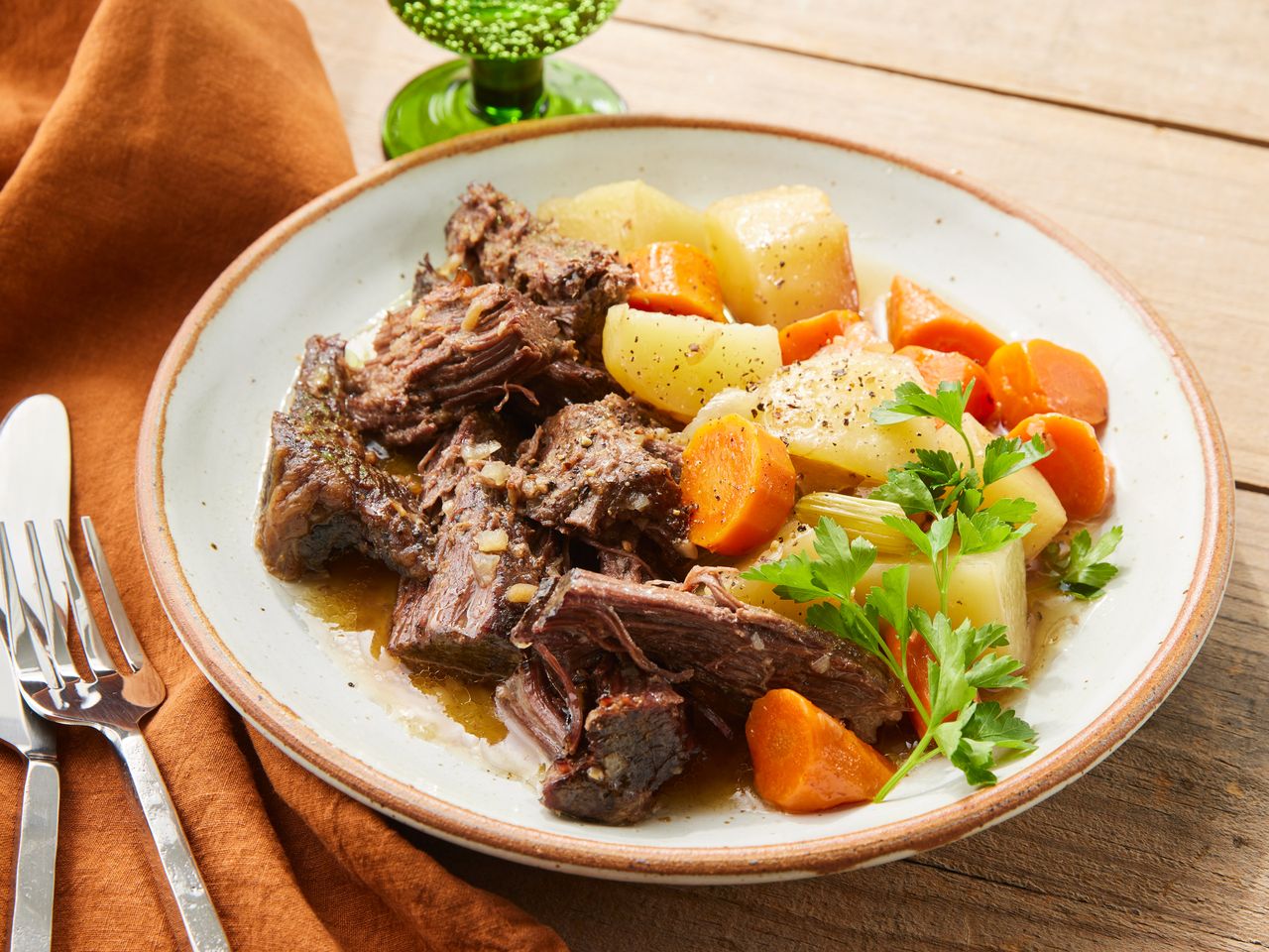A plated serving of Marie's easy slow cooker pot roast, served with carrots and potatoes, and garnished with fresh parsley