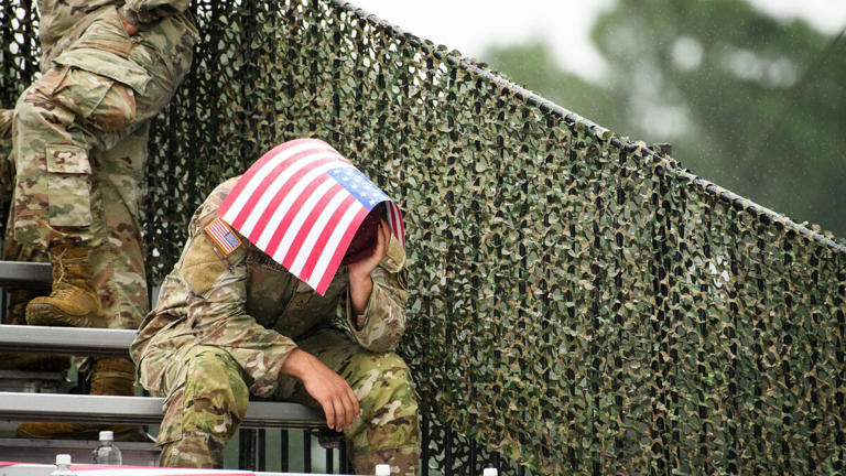 Un soldat utilise un drapeau américain pour se protéger de la pluie pendant qu'il attend le discours du président Donald Trump à Fort Bragg, le mardi 10 janvier 2025. (Illustration) Andrew Craft / Iconsport