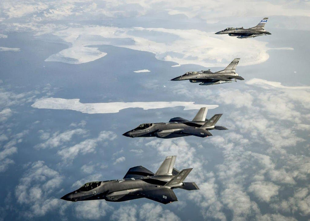 United States F-35 fighter jets, front, and F-16 fighter jets, back, fly over Greenland on October 7, 2025.