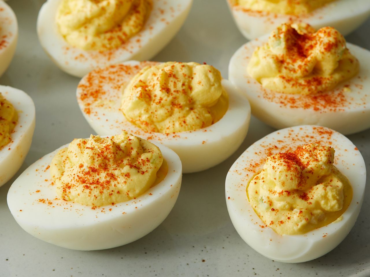 close up view of Deviled Eggs garnished with paprika on a platter
