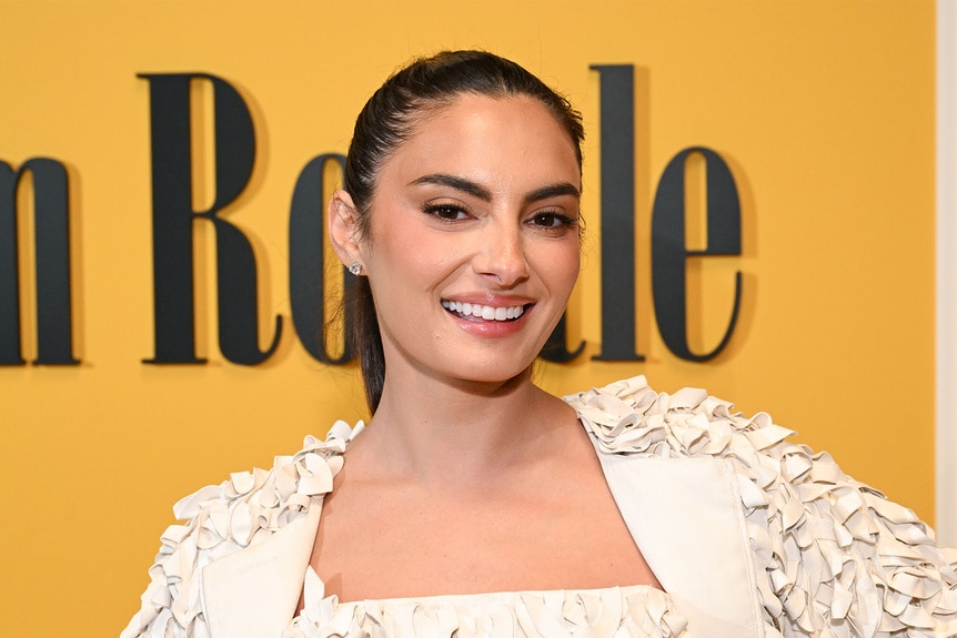 Paige DeSorbo smiling in front of a step and repeat.