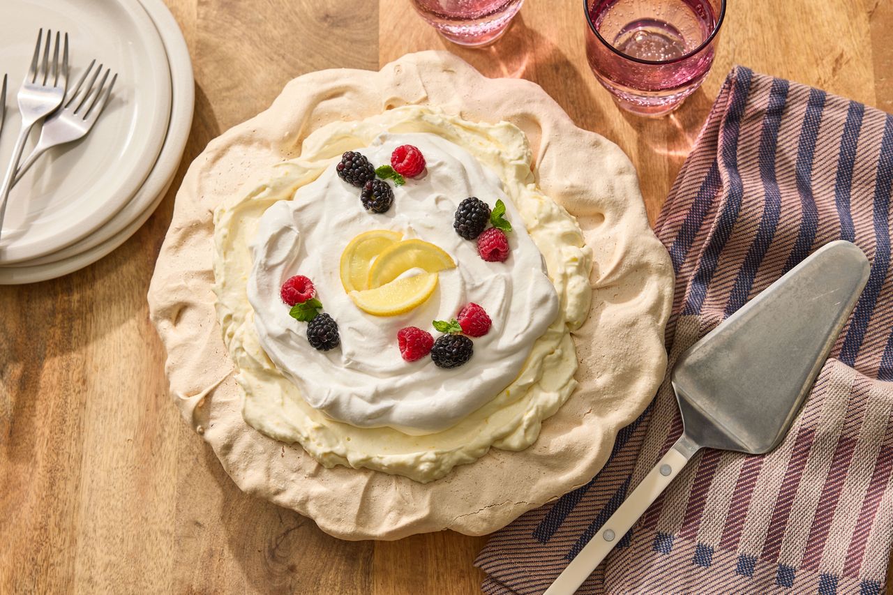 Angel Pie decorated and ready to serve on a wooden surface with plates and a pie server alongside