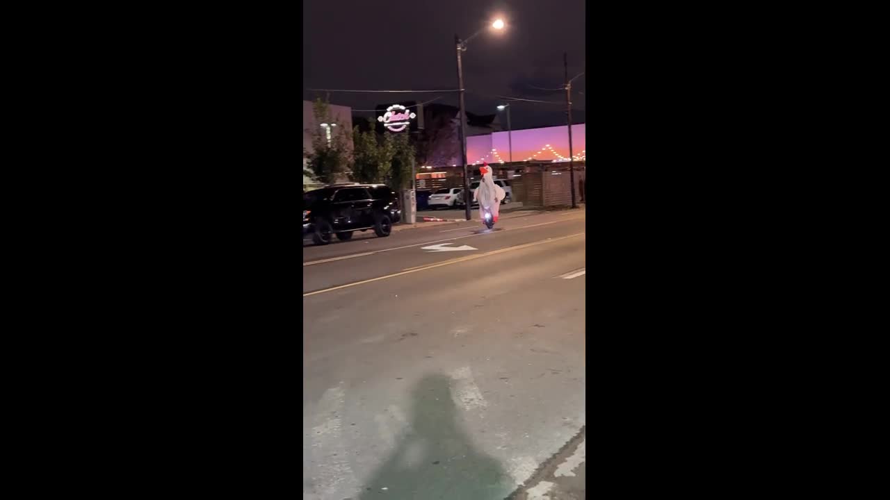 Inflatable chicken mascot rides electric unicycle in Houston, Texas, USA