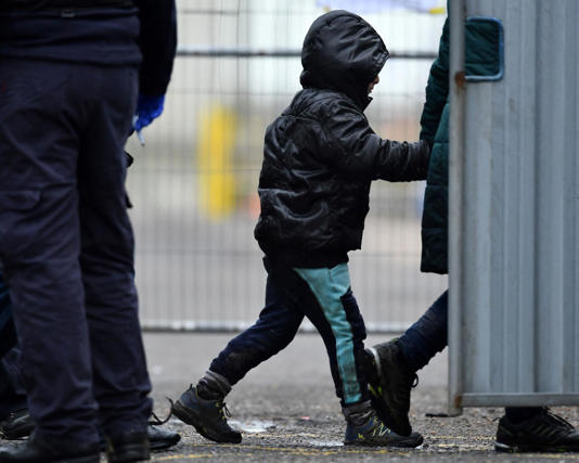 Border Force officers assisting a child. Photograph: Ben Stansall/AFP/Getty Images