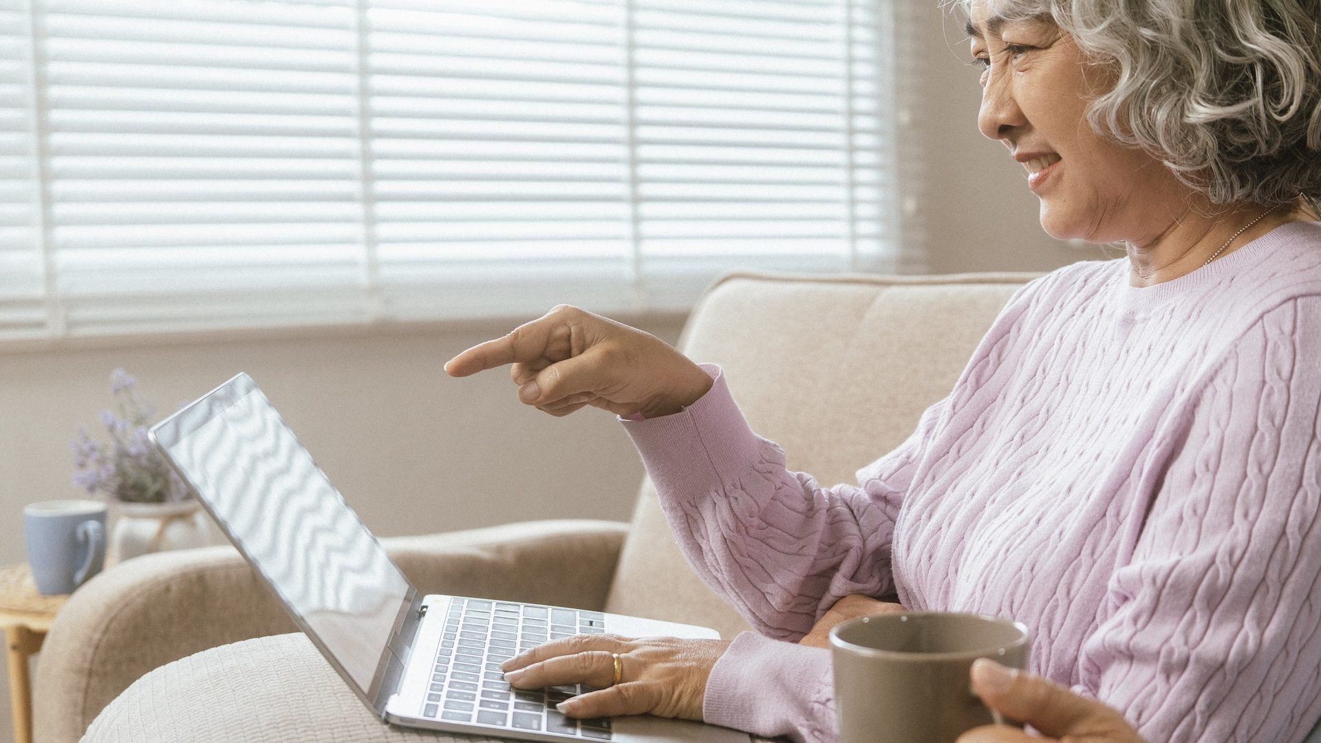 senior couple and documents with laptop for finance, budget planning or retirement annuity on sofa. Elderly man, woman or house with smile, computer or paperwork for pension fund or insurance