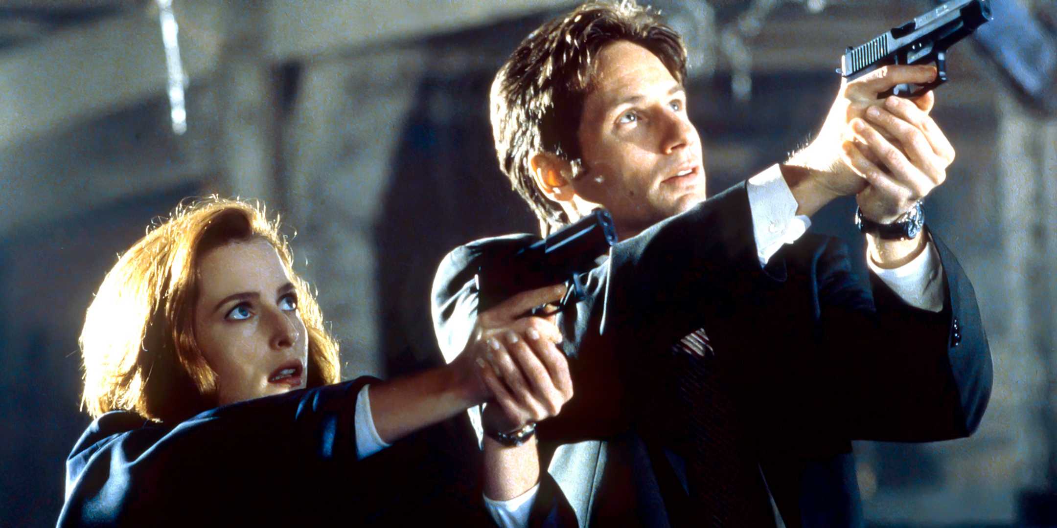Mulder and Scully aiming their guns upwards at something in The X-Files