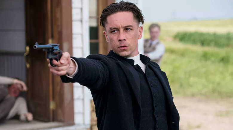 Killian Scott as Seth Davenport pointing a gun in Damnation