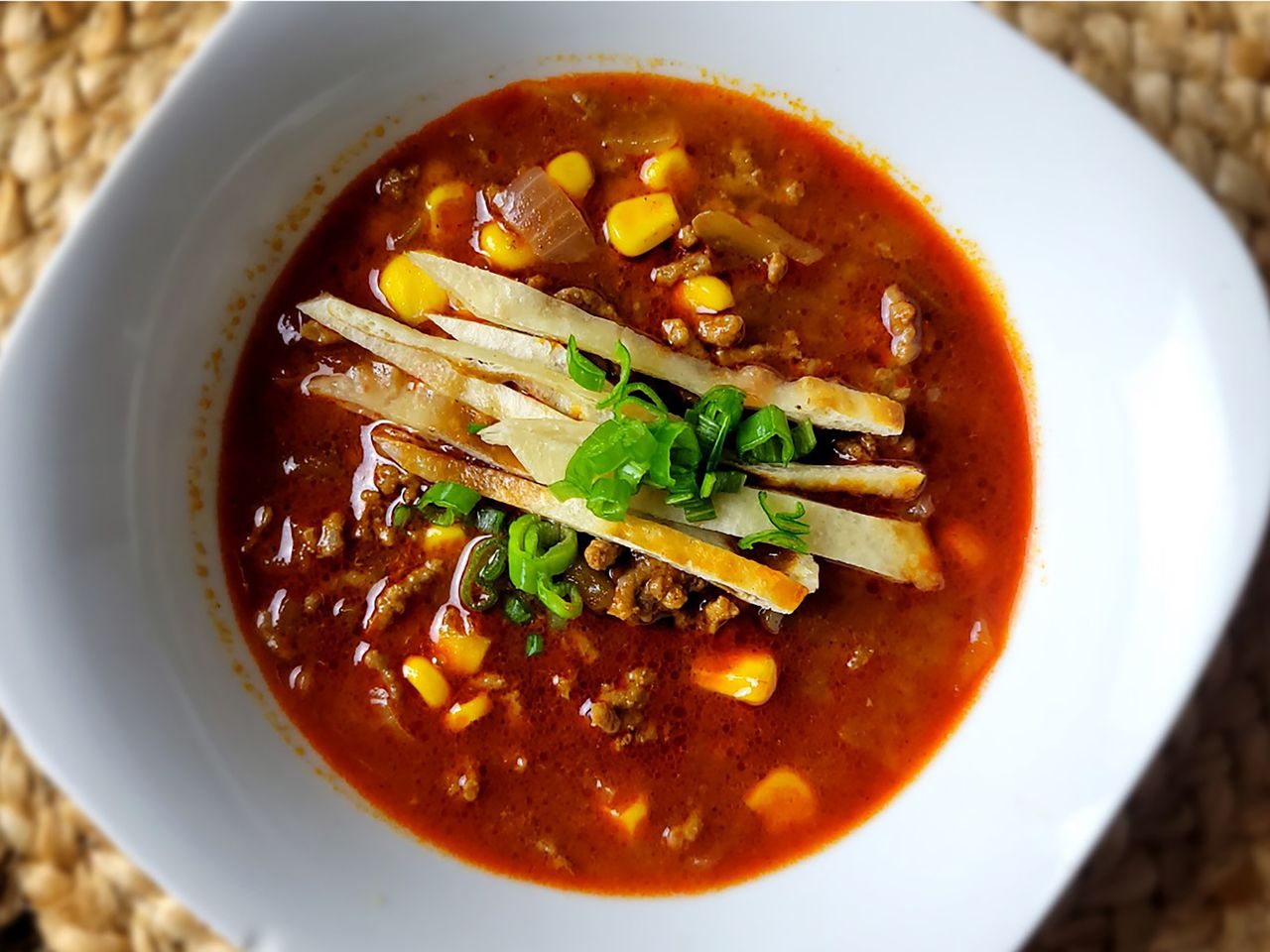 overhead view of taco soup with beef and corn in white square bowl