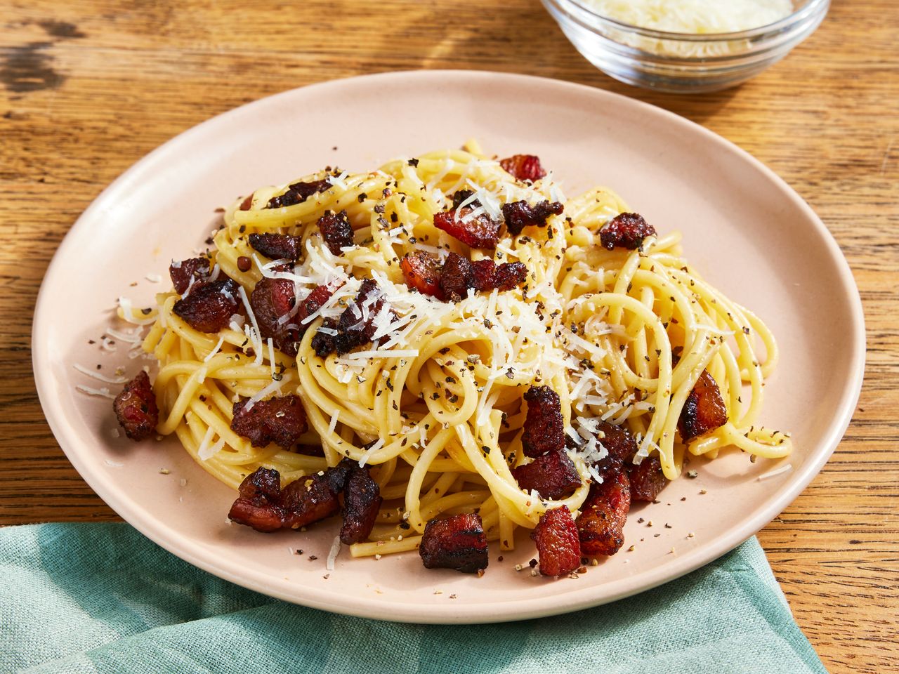 high angle looking at a plate full of spaghetti alla carbonara garnished with cheese