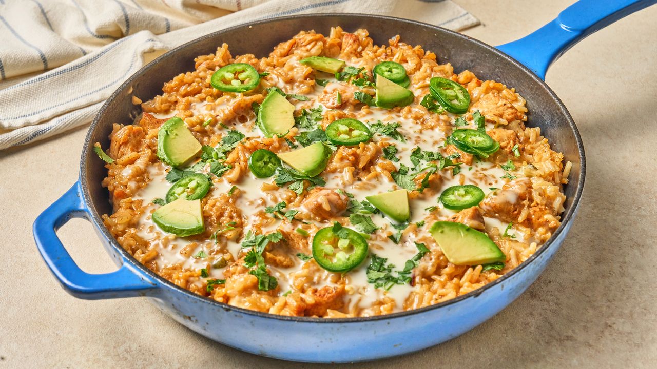 blue cast iron skillet with handle containing Mexican happy plate queso chicken and rice