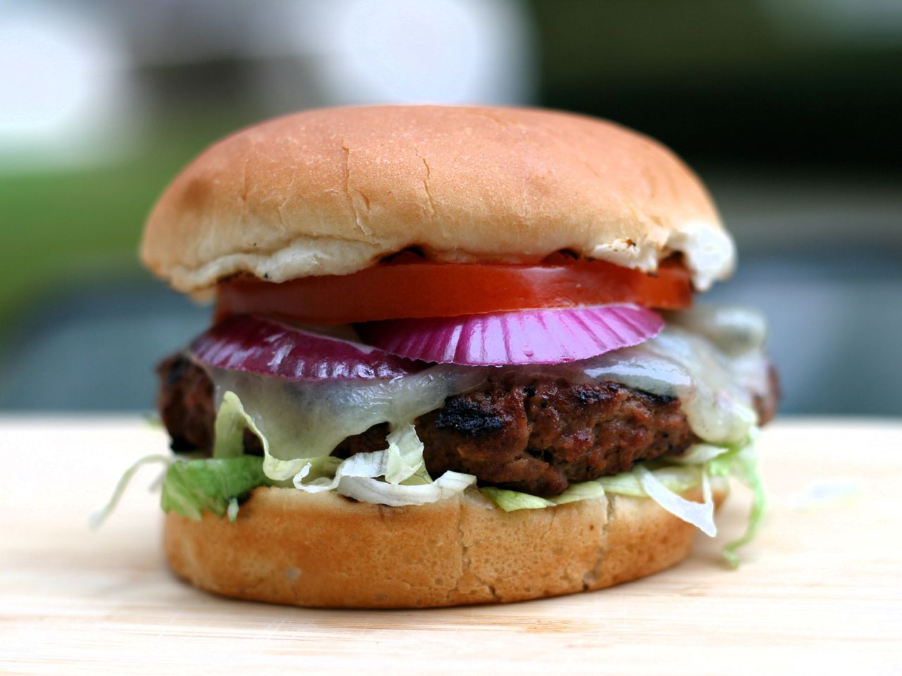 Burger with lettuce, tomato, and red onion