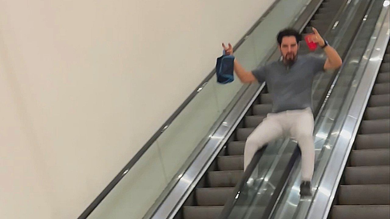 Drunk man slides down broken escalator rail
