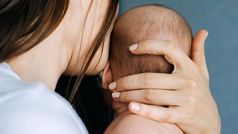 A woman holds a baby.