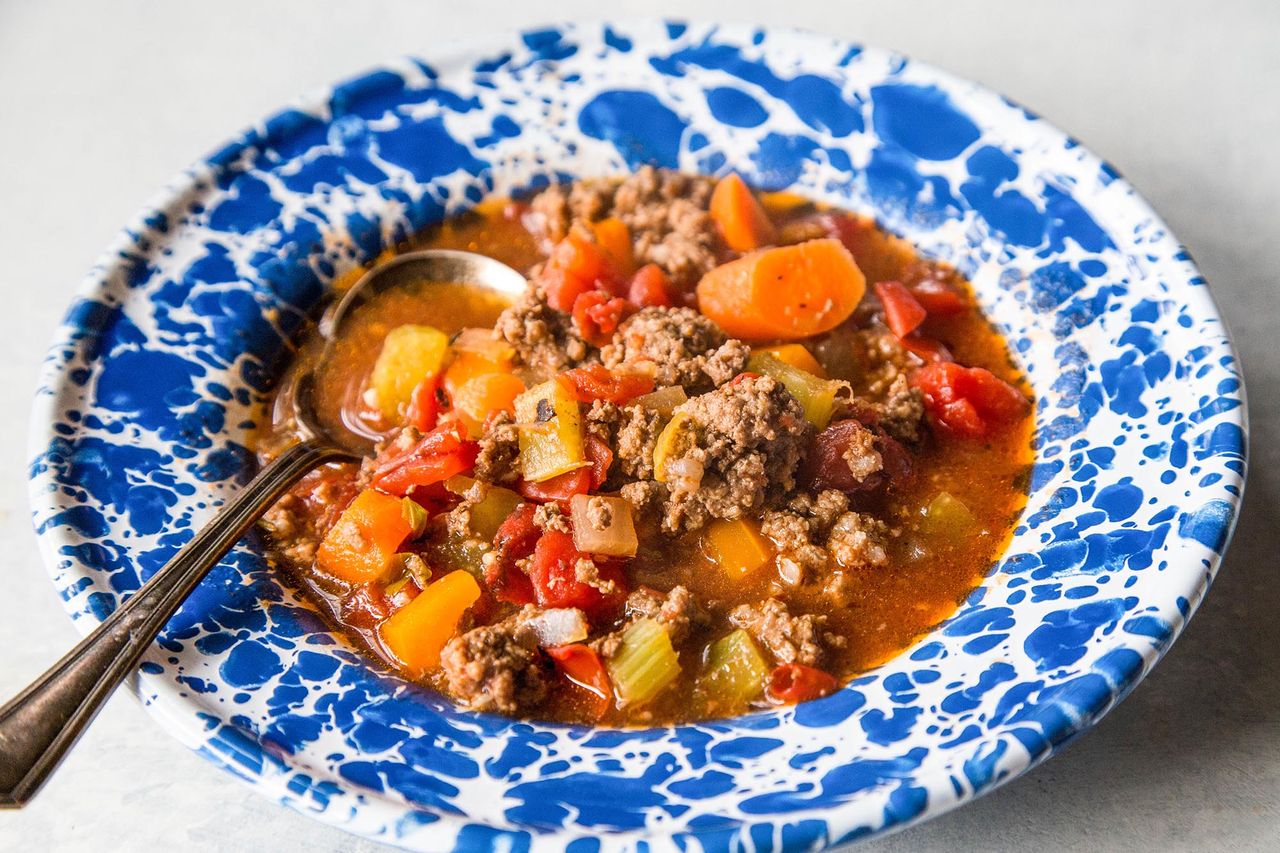 A blue bowl with hamburger soup, ready to eat.