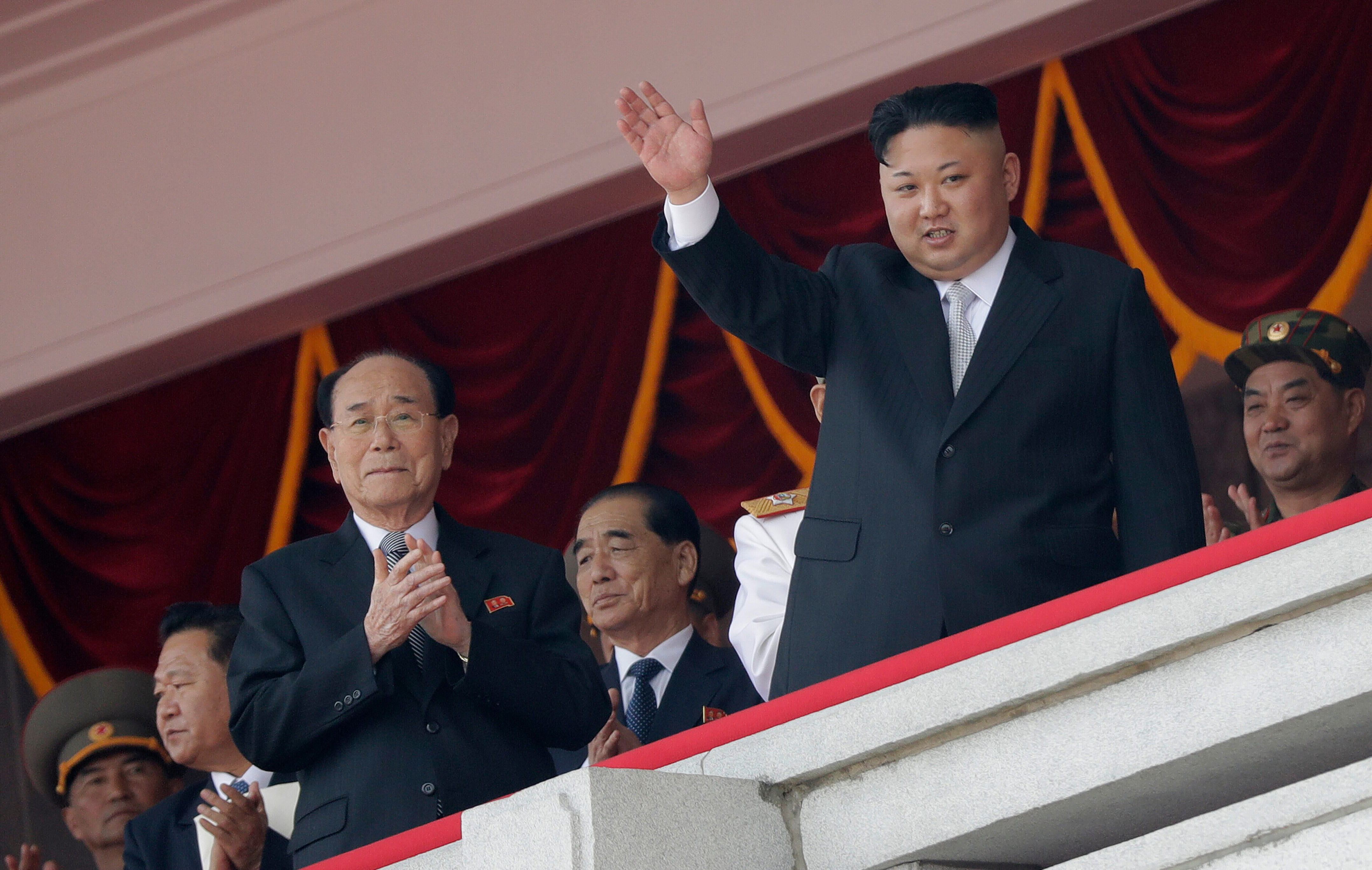 Kim Yong-nam, tercero por la izquierda, aplaude mientras el líder norcoreano, Kim Jong-un saluda durante un desfile militar en 2017 en Pyongyang. 