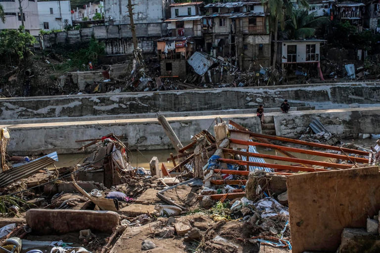 Residentes regresan a observar las casas destruidas por las inundaciones provocadas por el tifón Kalmaegi en una comunidad de Bacayan, en Cebú (Filipinas).