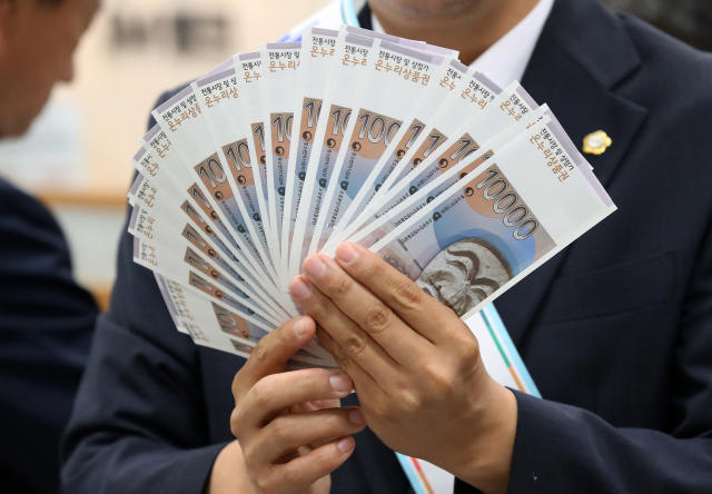 대구 중구 iM뱅크 중구청지점에서 열린 '추석맞이 전통시장 온누리상품권 구매 행사'에서 관계자들이 전통시장 활성화를 위해 구매한 상품권을 펼쳐 보이고 있다. 사진은 기사 내용과 무관함. 뉴스1