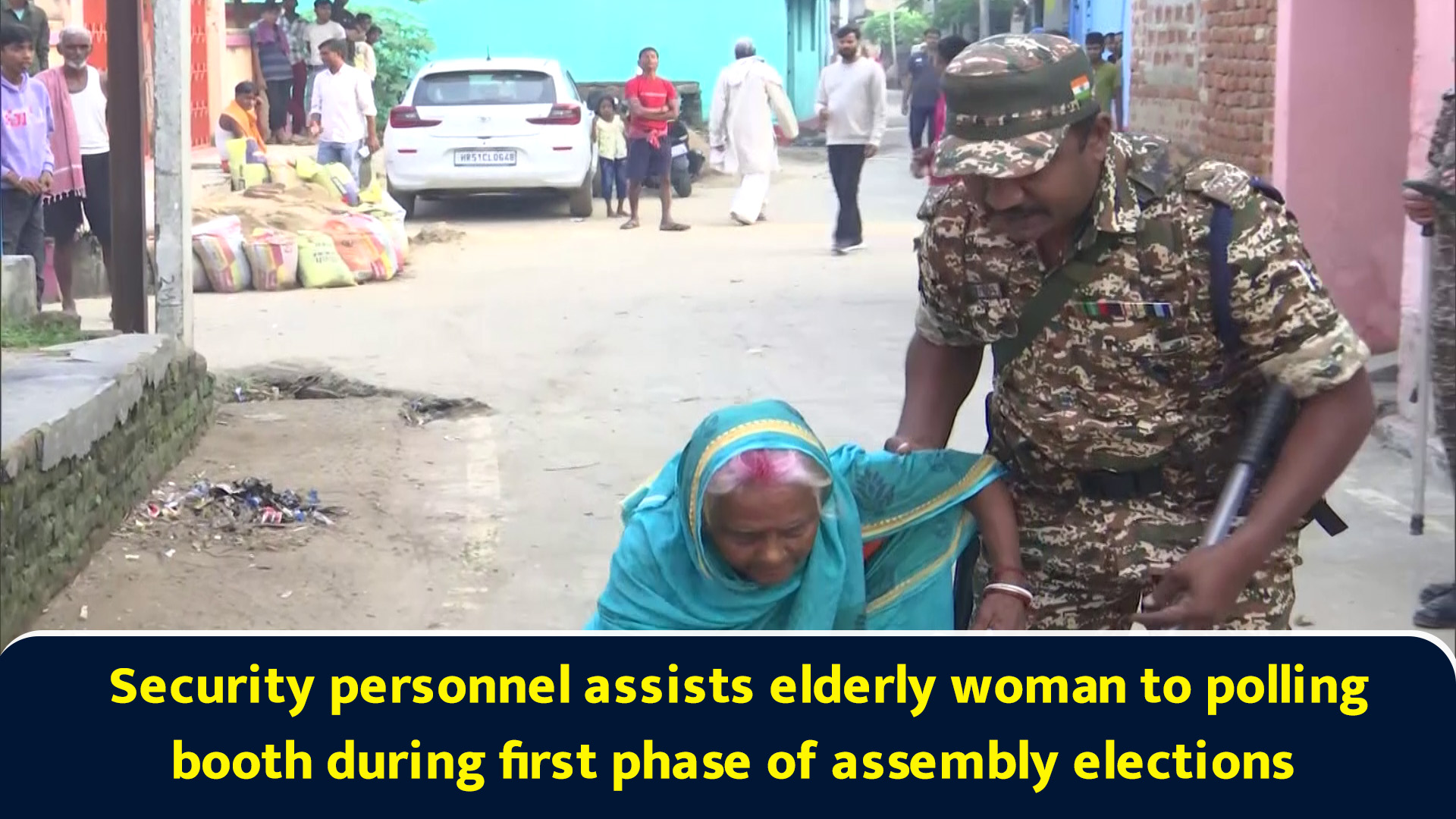 Security personnel assists elderly woman to polling booth during first ...