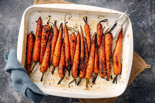 Close-up overhead view of a bunch of oven roasted carrots just out of the oven. Inspired by a Yottam Ottolenghi recipe, cooked w