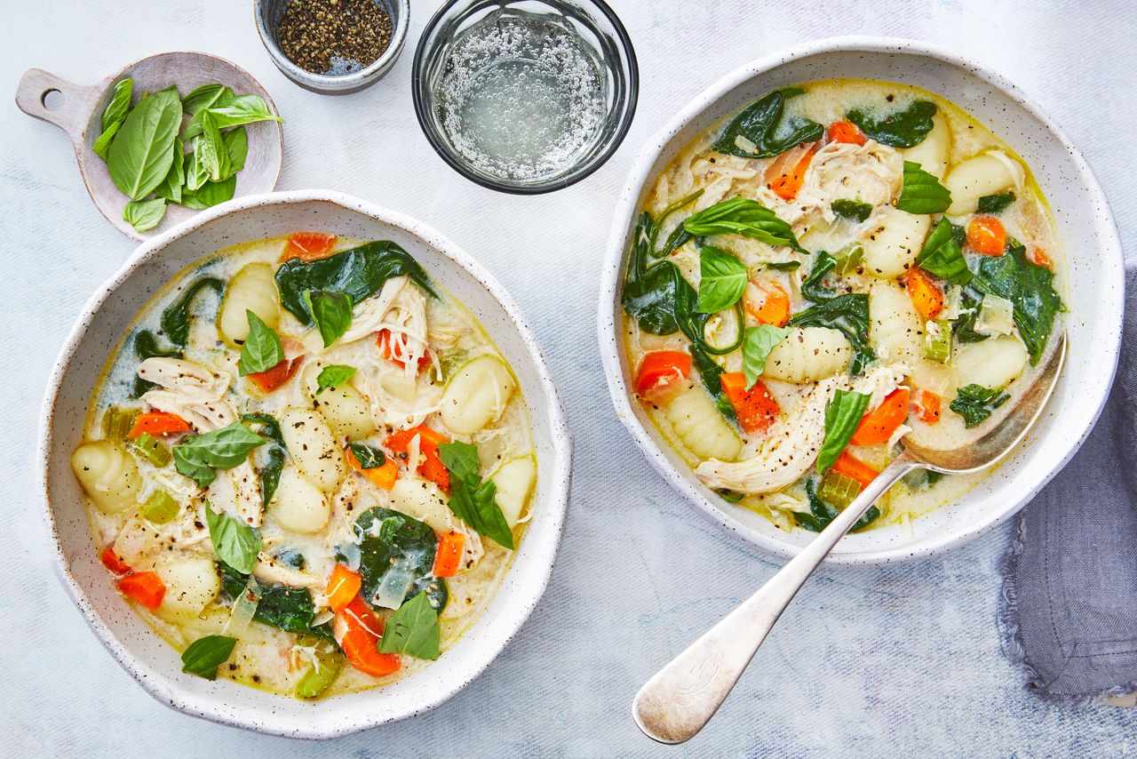 Southern Living Chicken Gnocchi Soup two servings in bowls with extra basil and pepper alongside