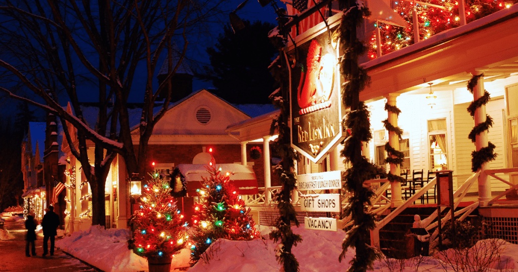 exterior of the red lion inn decorated in christmas lights with snow on the ground in stockbridge ma