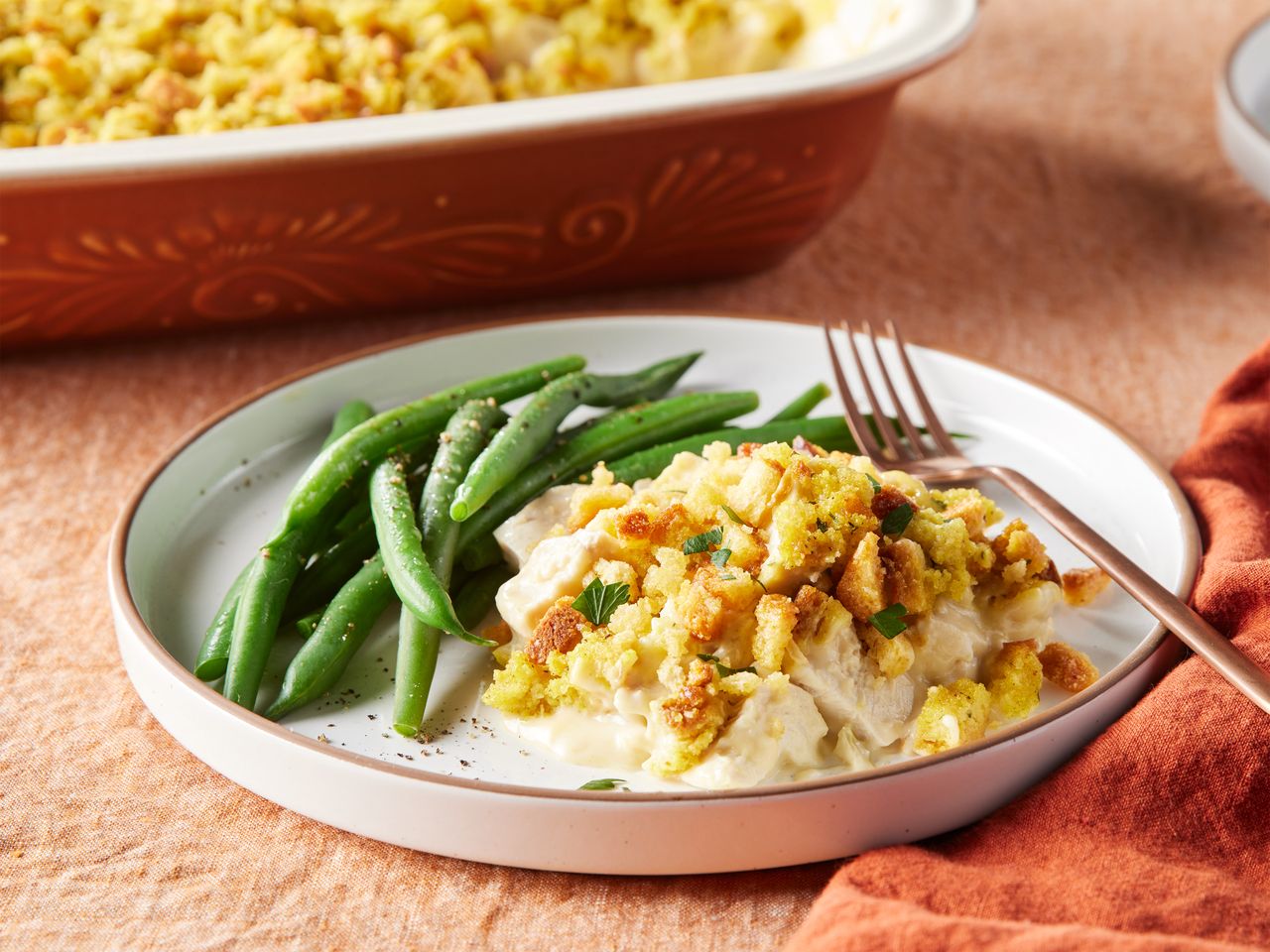 A serving of Aunt Jewel's chicken dressing casserole served with green beans