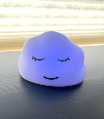 Cloud-shaped night light with a peaceful face, ideal for creating a calming atmosphere in bedrooms or nurseries