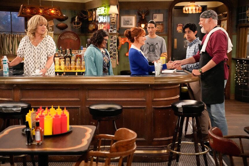The cast stands around a bar on Happy's Place Episode 201.