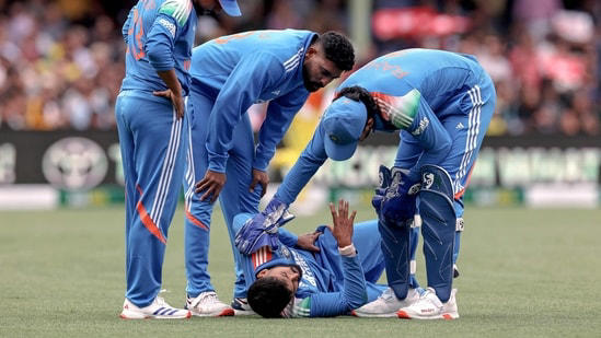 Shreyas Iyer (2R) is being checked by his teammates after he falls on the ground while taking a catch during the third ODI match vs Australia
