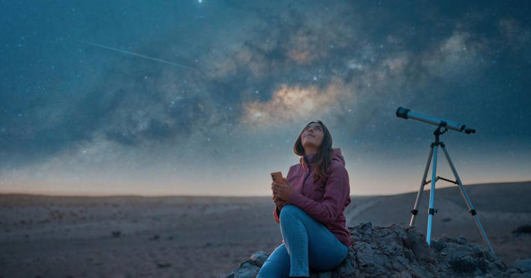 A woman sitting in the desert alone, watching the starry sky and the Milky Way in the background (Representative Image Source: Getty | Oscar Gutierrez Zozulia)