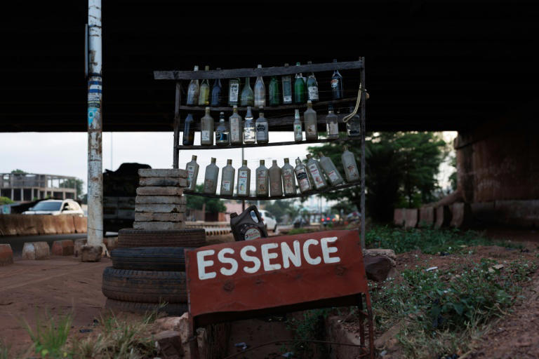 Des bouteilles vides sur un stand de vente d'essence au bord d'une route à Bamako, le 7 octobre 2025 au Mali