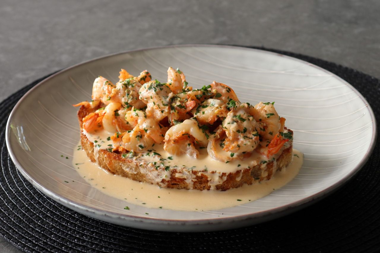 Creamy shrimp on toast on a white plate