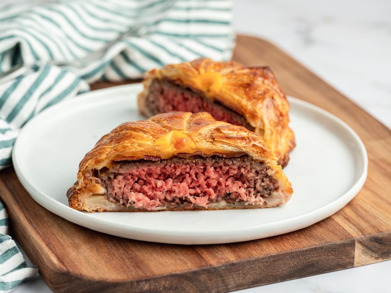 Cheeseburger wellington served on a white plate.