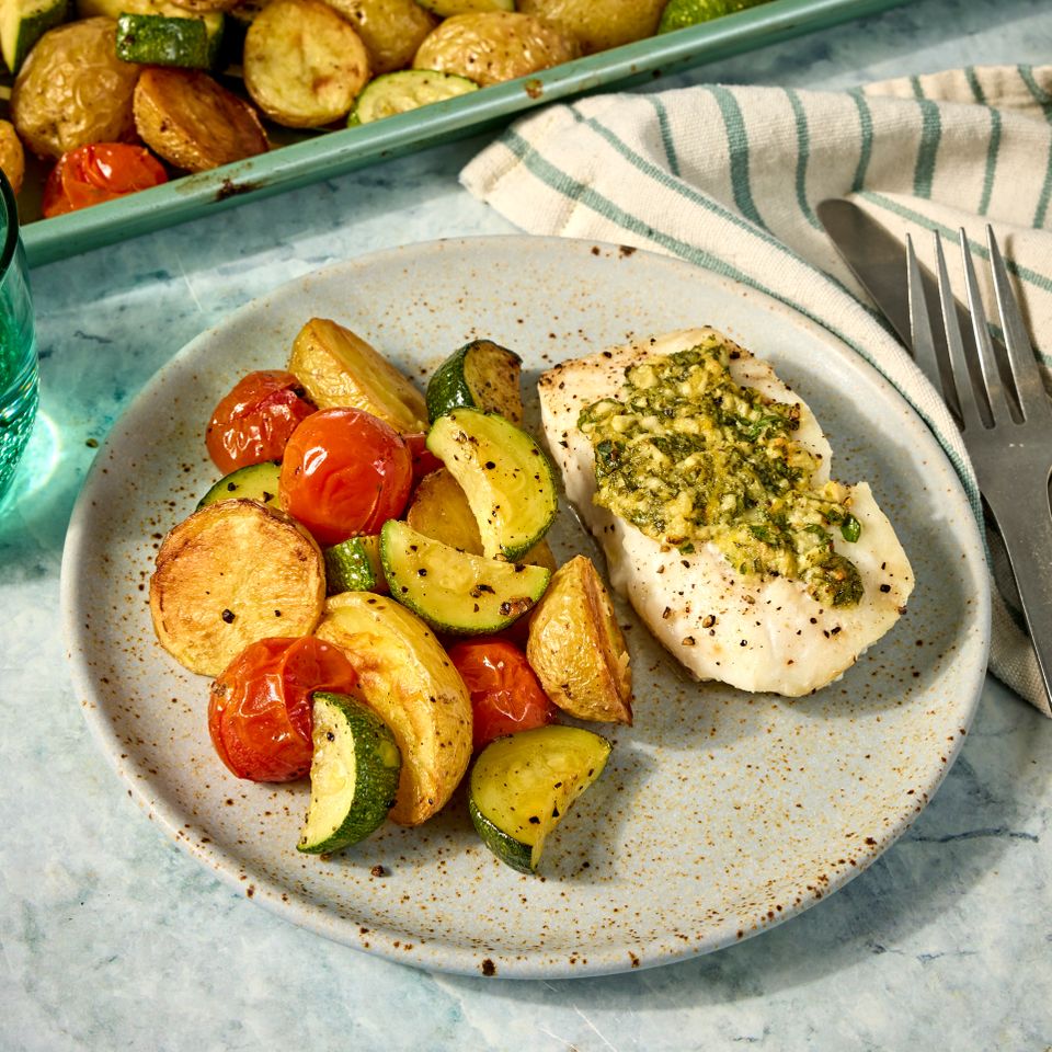 A recipe photo of Sheet-Pan Lemon-Garlic Fish with Zucchini, Cherry Tomatoes & Potatoes.